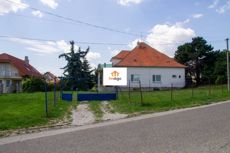 INVESTIČNÁ PRÍLEŽITOSŤ – Na predaj Komplexné centrum v Nitre  - Rodinný dom na ulici Pod sokolom v Nitre s červenou strechou a priestrannou záhradou.