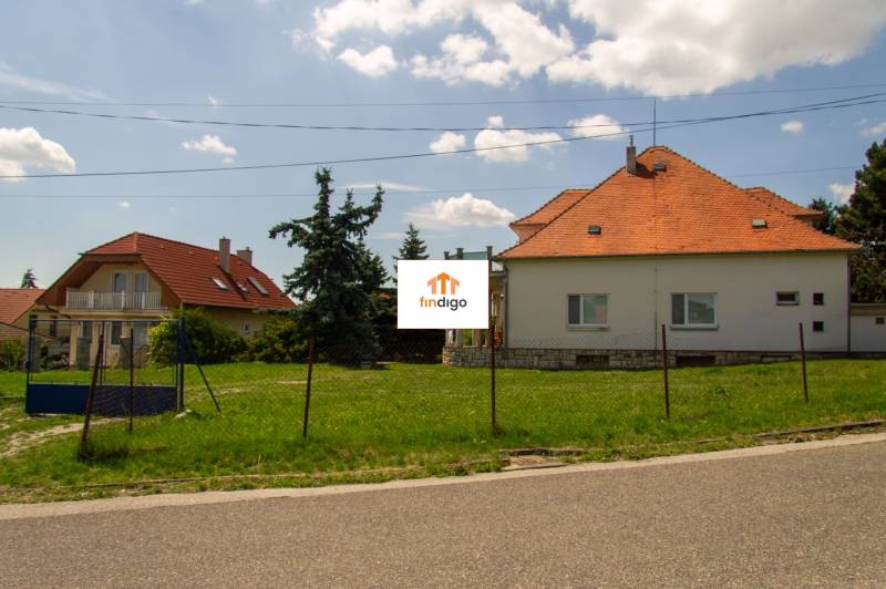 INVESTIČNÁ PRÍLEŽITOSŤ – Na predaj Komplexné centrum v Nitre  - Rodinný dom na ulici Pod sokolom v Nitre s červenou strechou a záhradou.