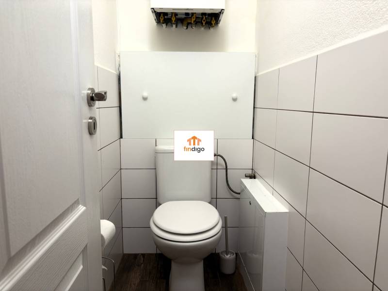 PREDAJ-  2 izbový byt neďaleko Nitry v obci Jarok - Kúpeľňa s bielym obkladom a toaletou v 2-izbovom byte, jednoduchý a čistý dizajn.