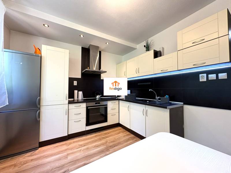 PREDAJ-  2 izbový byt neďaleko Nitry v obci Jarok - Kuchyňa v 2-izbovom byte s bielymi skrinkami a nerezovou chladničkou.