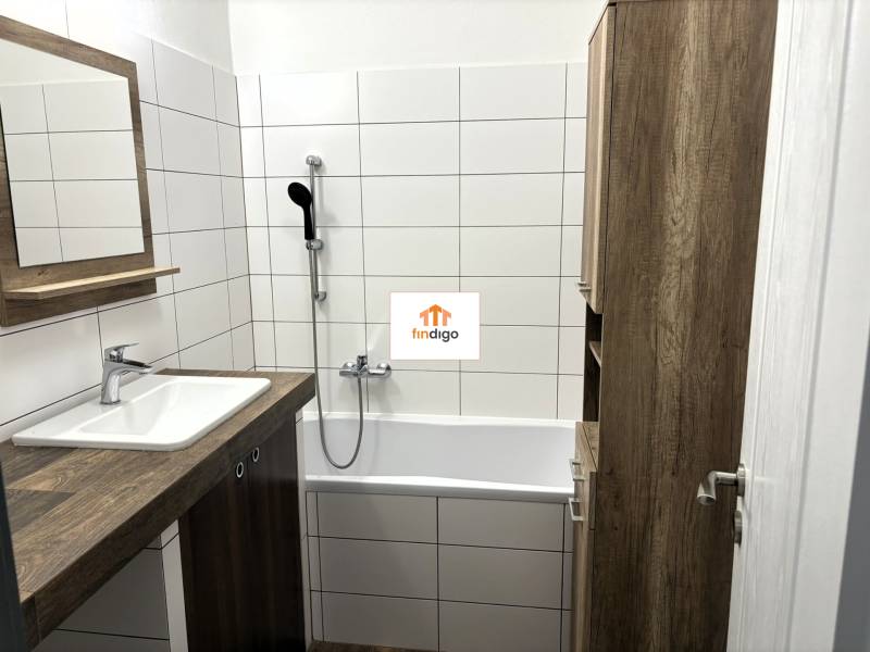 PREDAJ-  2 izbový byt neďaleko Nitry v obci Jarok - Kúpeľňa v 2-izbovom byte s vaňou, umývadlom a dreveným nábytkom.