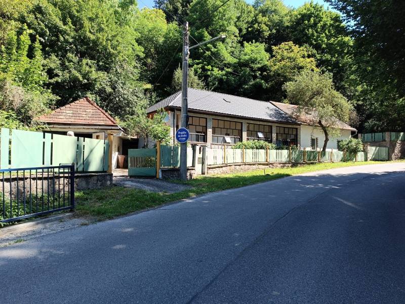 Na predaj  dom v obci Vyhne iba 400m od Vodného raja.  - Rodinný dom na ulici Vyhne obklopený zeleňou a plotmi, slnečný deň.