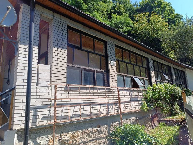 Na predaj  dom v obci Vyhne iba 400m od Vodného raja.  - Dom na ulici Vyhne s presklenou verandou a kamenným základom, obklopený zeleňou.