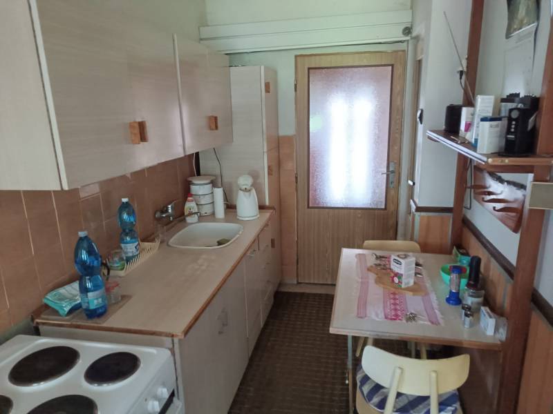 Na predaj  dom v obci Vyhne iba 400m od Vodného raja.  - Jednoduchá kuchyňa s dreveným nábytkom, drezom, sporákom a malým jedálenským stolom na ulici Vyhne v rodinnom dome.