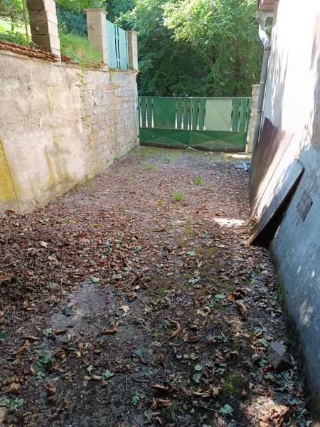 Na predaj  dom v obci Vyhne iba 400m od Vodného raja.  - Oplotený priestor pri rodinnom dome na ulici Vyhne, so zelenou bránou.