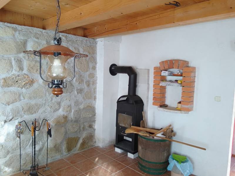 Štýlový rekreačný domček Levice - Chata s kachľami, kamennou stenou a podlahou s dreveným dekorom.