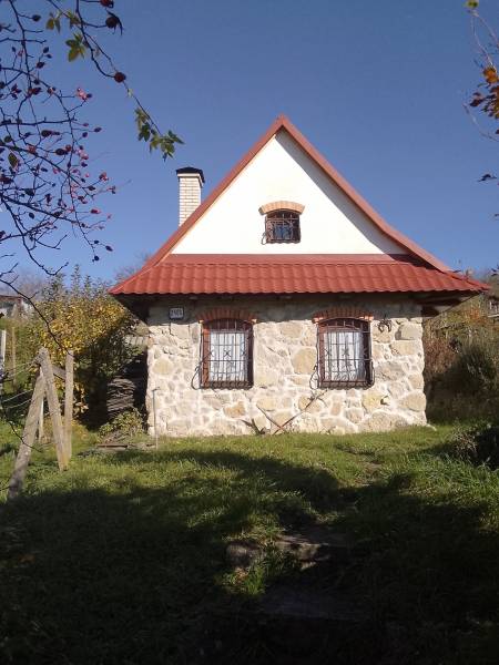 Štýlový rekreačný domček Levice - Klasická kamenná chata v Starých Leviciach, rekreačná lokalita, obklopená zeleňou a dreveným plotom.