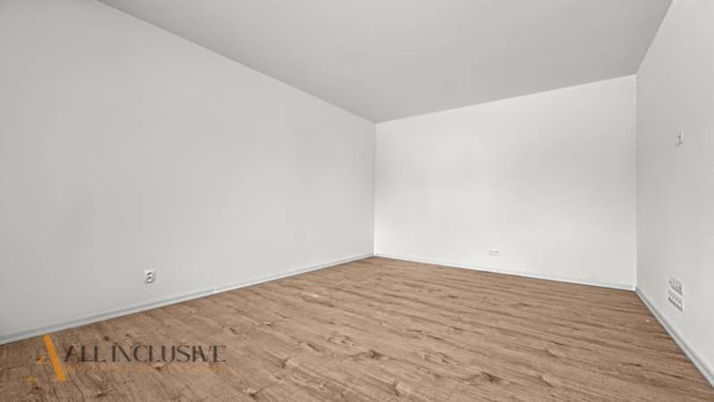 IDEÁLNY 1 IZBOVÝ BYT | VEĽKÉ RIPŇANY | TOPOĽČANY - Priestranná miestnosť v 1-izbovom byte s podlahou s dreveným dekorom a bielymi stenami.