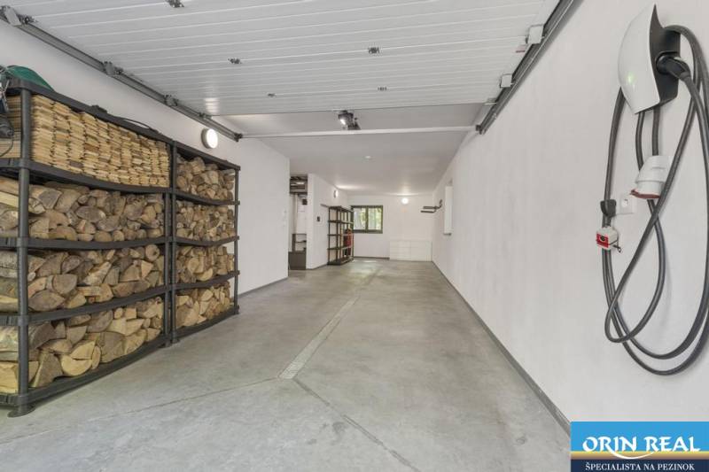 PREDAJ 8 IZB.REKREAČNEJ CHATY - VILY V MODRE HARMÓNII - Garáž s drevom, hadicou a úložným priestorom, na ulici Piesok, pri chate.