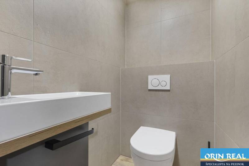 PREDAJ 8 IZB.REKREAČNEJ CHATY - VILY V MODRE HARMÓNII - Minimalistická kúpeľňa, biele umývadlo a toaleta, jednoduchý dizajn. Vhodné pre domácnosť.