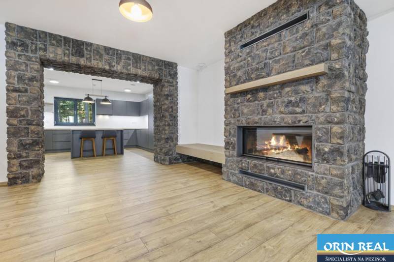 PREDAJ 8 IZB.REKREAČNEJ CHATY - VILY V MODRE HARMÓNII - Interiér s krbom a kameňom, priestor spája obývačku a kuchyňu.