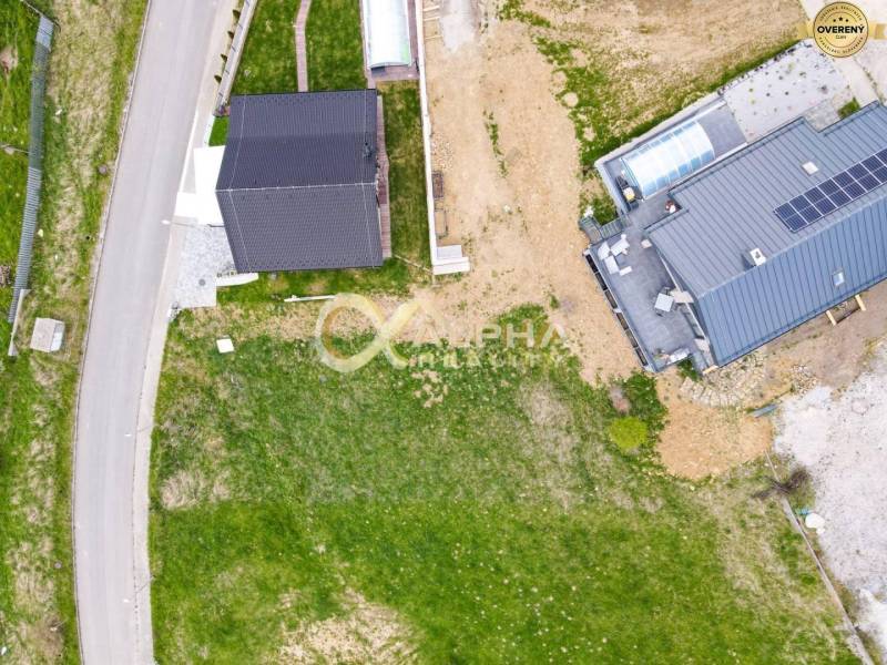 Stavebný pozemok lokalita Slnečná úboč, Levočská Dolina, okres Levoča - Letecký pohľad na pozemky vhodné na bývanie v Levoči s dvoma domami a ulicou.