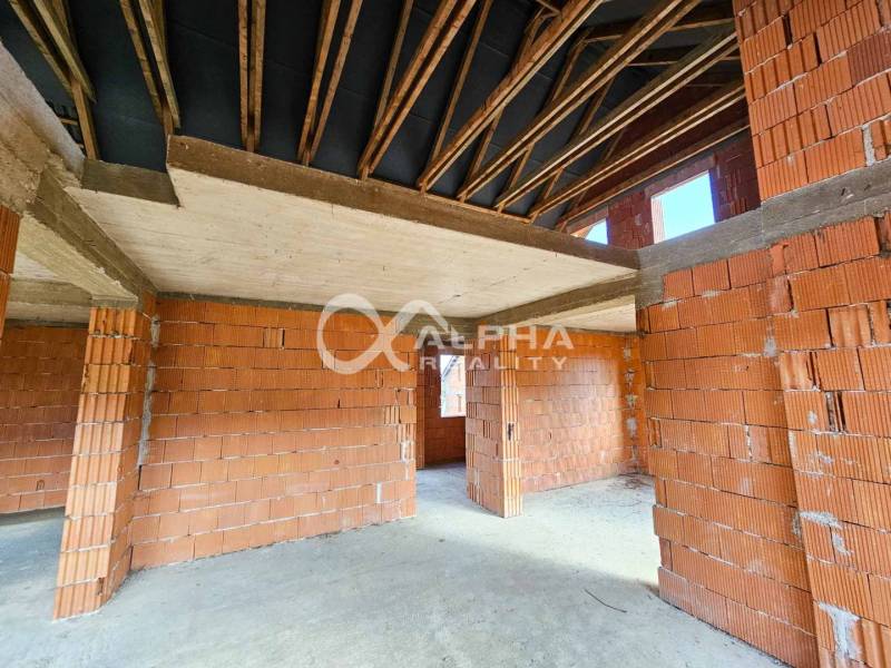 Rodinný dom, obec Spišský Hrhov, okres Levoča - Rodinný dom v štádiu výstavby s tehlovými stenami a priznanými nosníkmi na strope.