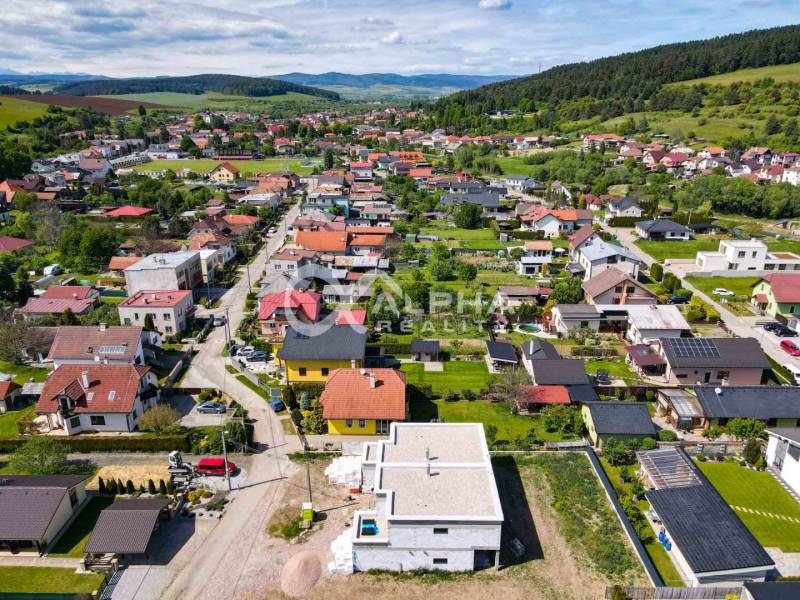 Exkluzívne na predaj, rodinný dom, obec Harichovce, okres Spišská Nová - Letecký pohľad na zástavbu rodinných domov v Harichovciach obklopenú zeleňou a kopcami.