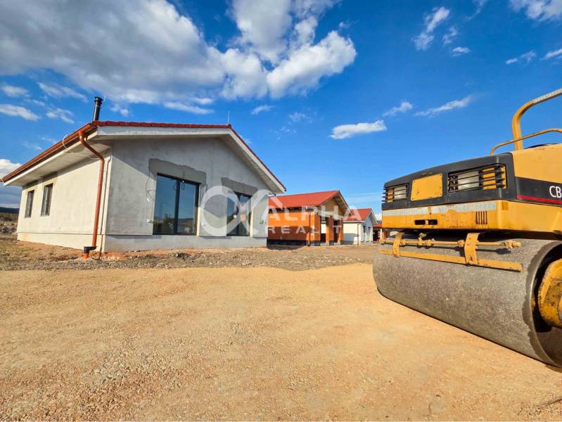 Exkluzívne novostavba rodinný dom - bungalov, Spišské Podhradie - Rodinný dom v Spišskom Podhradí so strojom na úpravu terénu za slnečného počasia.