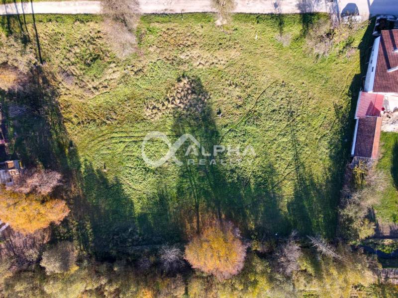 EXKLUZÍVNE stavebné pozemky, Spišské Podhradie - Letecký pohľad na pozemky určené na bývanie v Spišskom Podhradí, obklopené zeleňou a budovami.