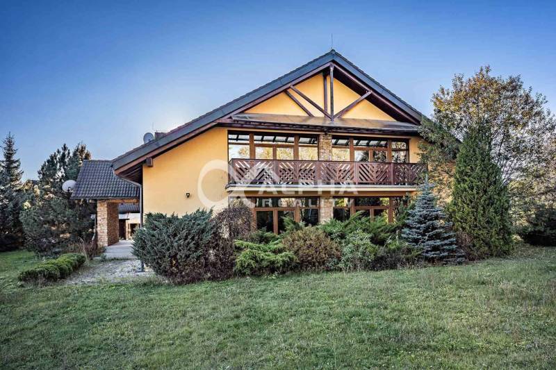 Exkluzívny rodinný dom, Veľká Lomnica, okres Kežmarok - Rodinný dom vo Veľkej Lomnici s drevenými prvkami, obklopený zeleňou a trávnikom.