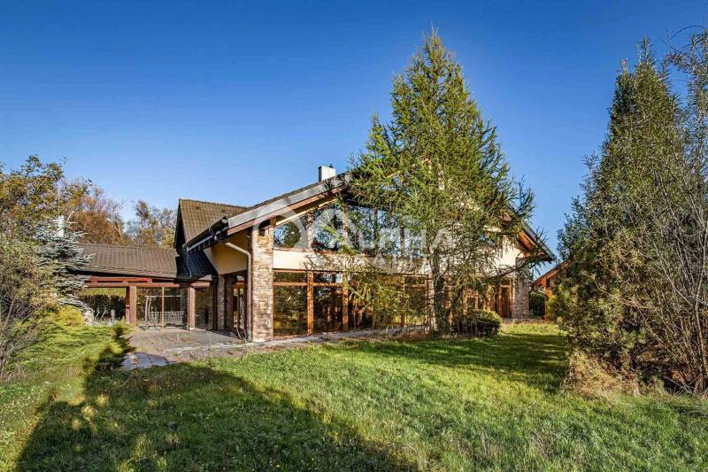 Exkluzívny rodinný dom, Veľká Lomnica, okres Kežmarok - Rodinný dom vo Veľkej Lomnici obklopuje zeleň, s kamennou fasádou a stromami v okolí.