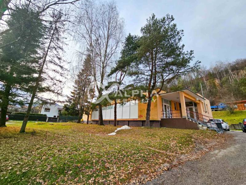 Budova s pozemkom, obec Helcmanovce, okres Gelnica - Budova v Helcmanovciach obklopená stromami, so schodiskom vedúcim k vchodu.