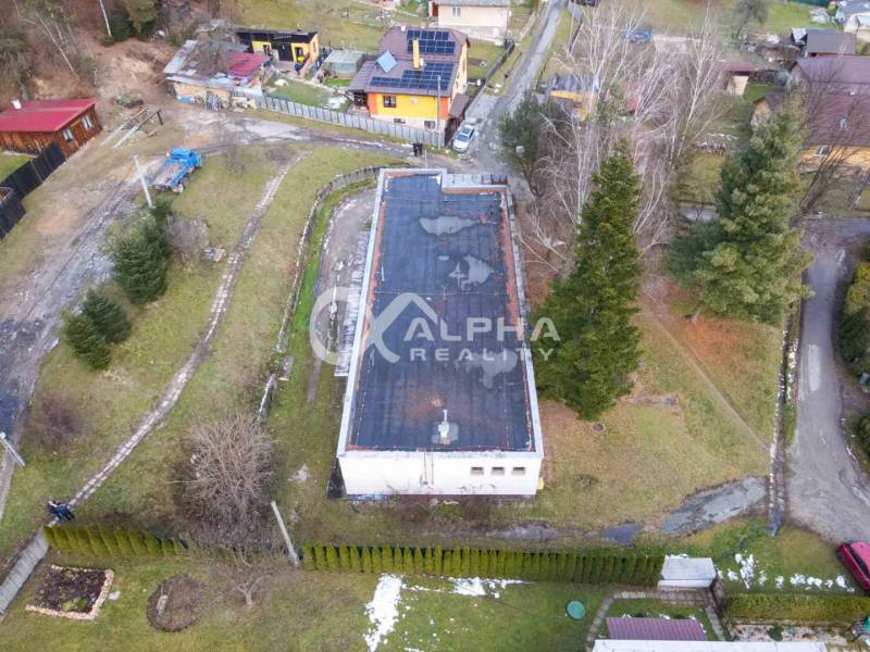 Budova s pozemkom, obec Helcmanovce, okres Gelnica - Letecký pohľad na budovu v Helcmanovciach, obklopenú zeleňou a okolitými domami.