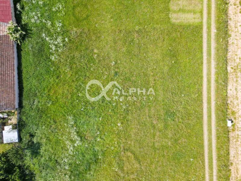 Pozemok 992m2, obec Betlanovce, okres Sp.N.Ves - Letecký pohľad na trávnaté pozemky na bývanie v Betlanovciach, so susedným domácim pozemkom.