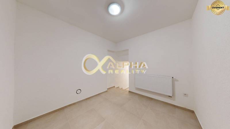 Polyfunkčný priestor na predaj, Zimná ul., Spišská Nová Ves - Prázdna miestnosť s bielymi stenami, krémovou podlahou a radiátorom v obchodných priestoroch.