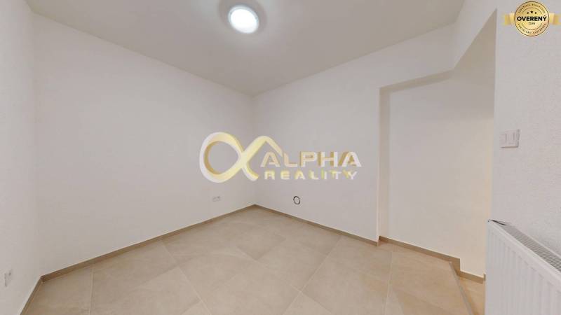 Polyfunkčný priestor na predaj, Zimná ul., Spišská Nová Ves - Interiér obchodných priestorov s dlažbou a bielymi stenami.