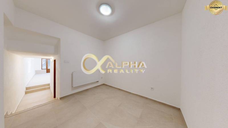 Polyfunkčný priestor na predaj, Zimná ul., Spišská Nová Ves - Interiér obchodných priestorov s bielymi stenami a dlažbou, prechodom do svetlej miestnosti.