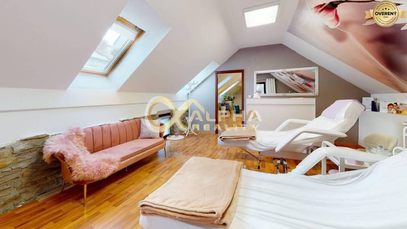 Prenájom priestorov, centrum, Spišská Nová Ves - Podkrovná kancelária s terapeutickými lehátkami a pohovkou, podlaha s dreveným dekorom.