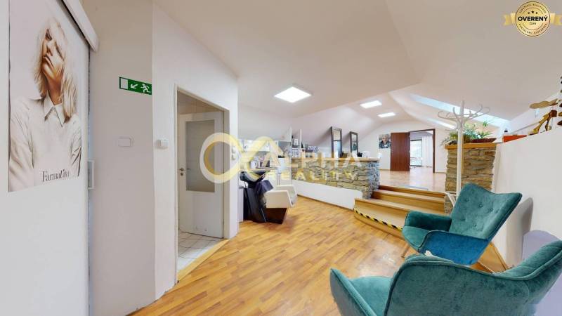 Prenájom priestorov, centrum, Spišská Nová Ves - Interiér kancelárie s podlahou s dreveným dekorom, kamennými stenami a pohodlnými stoličkami.