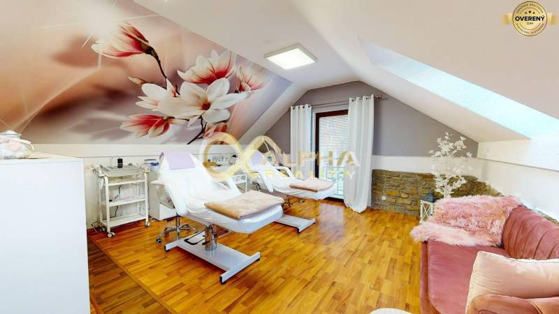 Prenájom priestorov, centrum, Spišská Nová Ves - Interiér kancelárie s kreslami a podlahou s dreveným dekorom, dekoratívna stena s kvetmi.