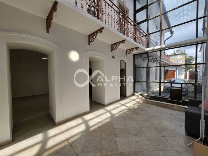 Prenájom obchodných priestorov, 268m2, Letná ulica, Spišská Nová Ves - Interiér obchodných priestorov s kamennou podlahou a presklenou stenou; svetlé miestnosti.