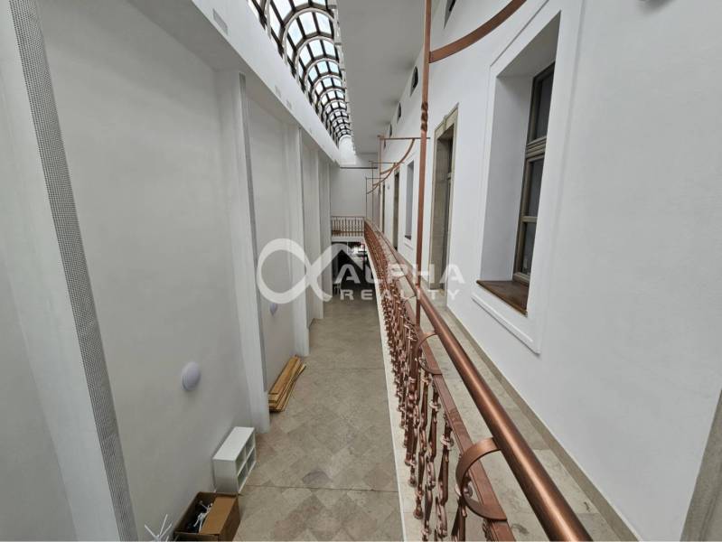 Prenájom obchodných priestorov, 268m2, Letná ulica, Spišská Nová Ves - Interiér obchodných priestorov s dláždenou podlahou a preskleným stropom a zábradlím.