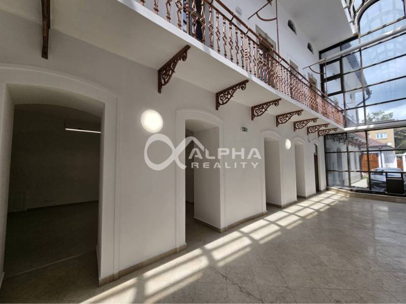 Prenájom obchodných priestorov, 268m2, Letná ulica, Spišská Nová Ves - Interiér obchodných priestorov s presklenými stenami a ozdobným kovovým zábradlím.