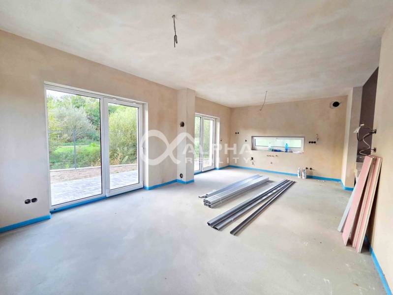 Rodinné domy, obec Danišovce, okr. Spišská Nová Ves - Priestranný interiér rodinného domu s veľkými oknami a prípravou na dokončenie.