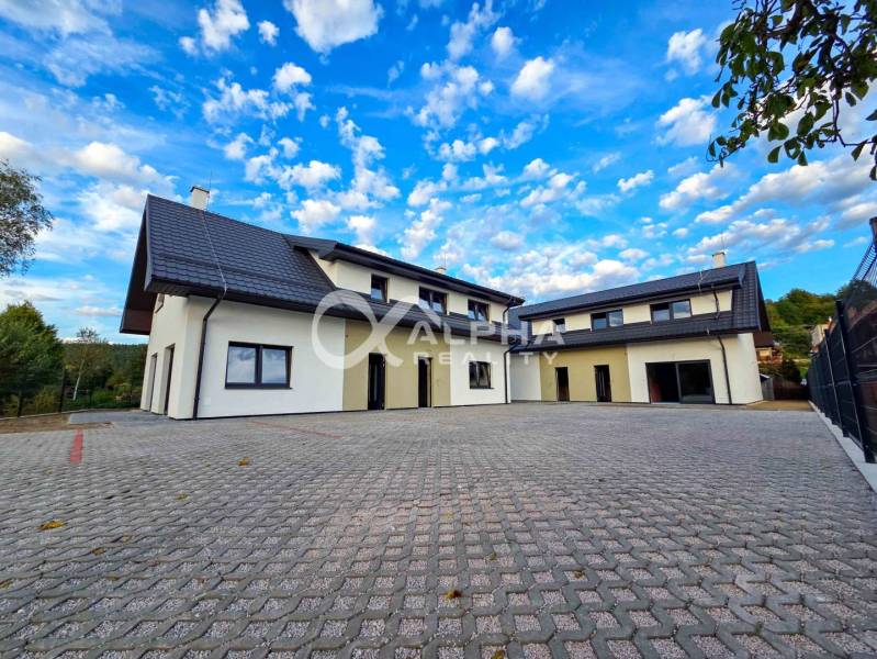 Rodinné domy, obec Danišovce, okr. Spišská Nová Ves - Rodinný dom v Danišovciach na ulici Danišovce, s veľkým dláždeným nádvorím a modrou oblohou.