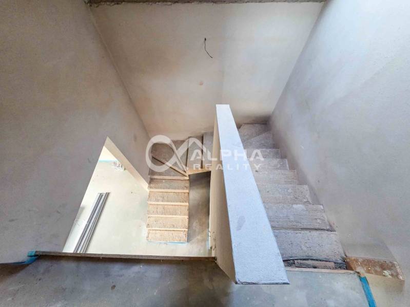 Rodinné domy, obec Danišovce, okr. Spišská Nová Ves - Betónové schodisko v rozostavanom rodinnom dome s bielym zábradlím.