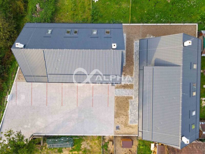 Rodinné domy, obec Danišovce, okr. Spišská Nová Ves - Pohľad zhora na strechy rodinného domu v Danišovciach s veľkým vydláždeným nádvorím.