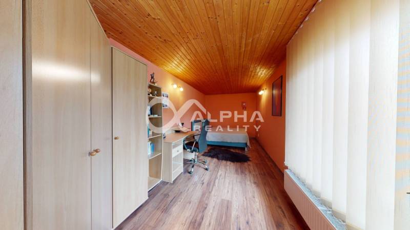 EXKLUZÍVNE Rodinný dom, širšie centrum, Spišská Nová Ves - Izba v rodinnom dome s podlahou s dreveným dekorom a pracovným stolom.