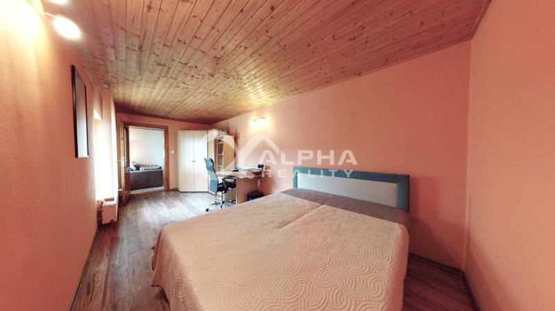 EXKLUZÍVNE Rodinný dom, širšie centrum, Spišská Nová Ves - Spálňa s podlahou s dreveným dekorom, pracovným stolom a manželskou posteľou v rodinnom dome.