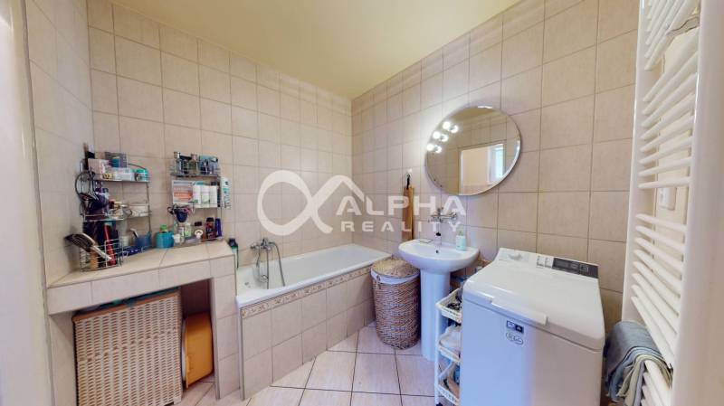 EXKLUZÍVNE Rodinný dom, širšie centrum, Spišská Nová Ves - Kúpeľňa v rodinnom dome s vaňou, práčkou a kruhovým zrkadlom.