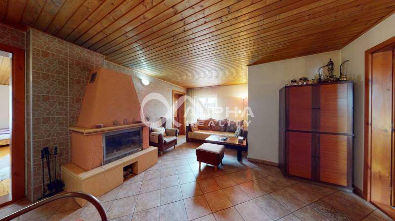 EXKLUZÍVNE Rodinný dom, širšie centrum, Spišská Nová Ves - Obývacia izba v rodinnom dome s krbom, dlažbou a sedacou súpravou.