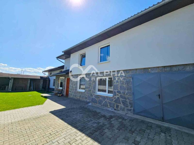 EXKLUZÍVNE Rodinný dom, širšie centrum, Spišská Nová Ves - Rodinný dom v Spišskej Novej Vsi s kamennou fasádou a zeleným trávnikom.