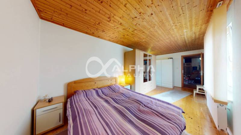 EXKLUZÍVNE Rodinný dom, širšie centrum, Spišská Nová Ves - Spálňa v rodinnom dome s dreveným stropom a podlahou s dreveným dekorom.