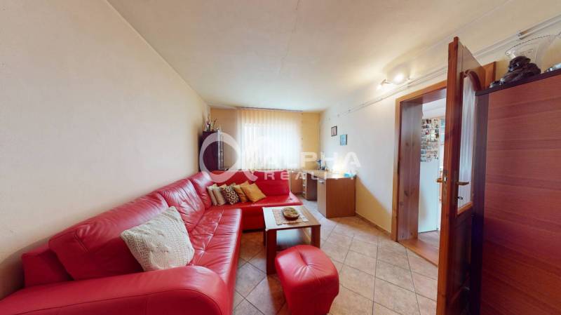 EXKLUZÍVNE Rodinný dom, širšie centrum, Spišská Nová Ves - Obývacia izba v rodinnom dome s červenou rohovou sedačkou a dlažbou na podlahe.