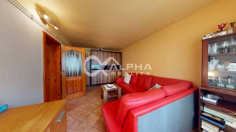 EXKLUZÍVNE Rodinný dom, širšie centrum, Spišská Nová Ves - Obývacia izba s červenou sedacou súpravou a sklenenou vitrínou v rodinnom dome.