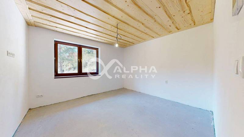 2i alebo 3i byt, Poráč, okres Spišská Nová Ves - Prázdna miestnosť rekreačného apartmánu s dreveným stropom a veľkým oknom.