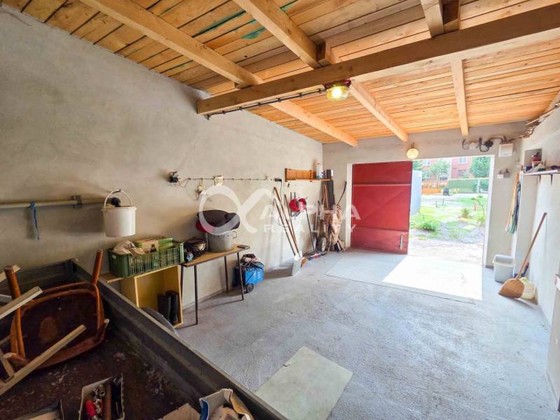 Prenájom garáž, centrum, Spišská Nová Ves - Interiér garáží s betónovou podlahou, dreveným stropom a potrebami na uskladnenie.