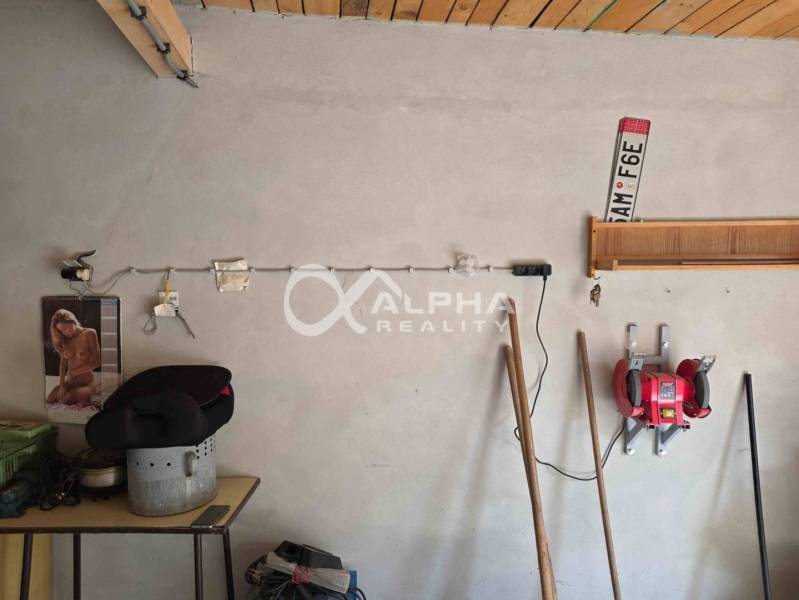 Prenájom garáž, centrum, Spišská Nová Ves - Stena v garáži s náradím a dekoračnými predmetmi.