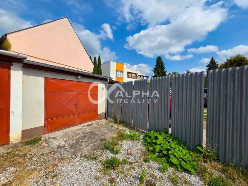 Prenájom garáž, centrum, Spišská Nová Ves - Garáže v Spišskej Novej Vsi s plechovým plotom, obložené červenými dverami.